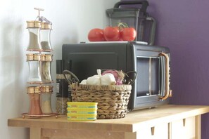 Una radio antigua, una cesta con verduras y una caja de pasta Cento sobre una superficie de madera.