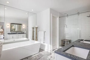 A modern bathroom with a large bathtub, a separate shower area, and a vanity with a sink. - Bull Path Manor by Rove - 4BR Family Home With Pool & Hot Tub (East Hampton)