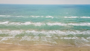 Een strand met helder water en een zandstrand.