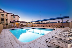 A swimming pool with lounge chairs, a covered area, and a building with balconies. - Southern #2068 Mesa (Mesa)
