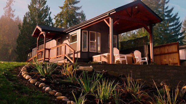A cabin with a covered porch, stone steps, and outdoor seating. - Skyriver Escape Riverfront With Hot Tub (Monroe)