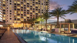 A hotel with a swimming pool, lounge chairs, and palm trees. - Stunning High-floor City View 1BR Hyde Beach House (Hollywood)
