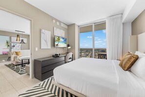 Een moderne hotelkamer met een groot bed, een bureau, een stoel en uitzicht op de stad.