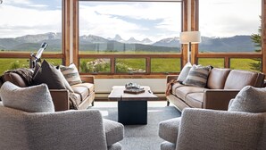 A room with two sofas facing a large window overlooking mountains. - Teton Melody (Driggs)