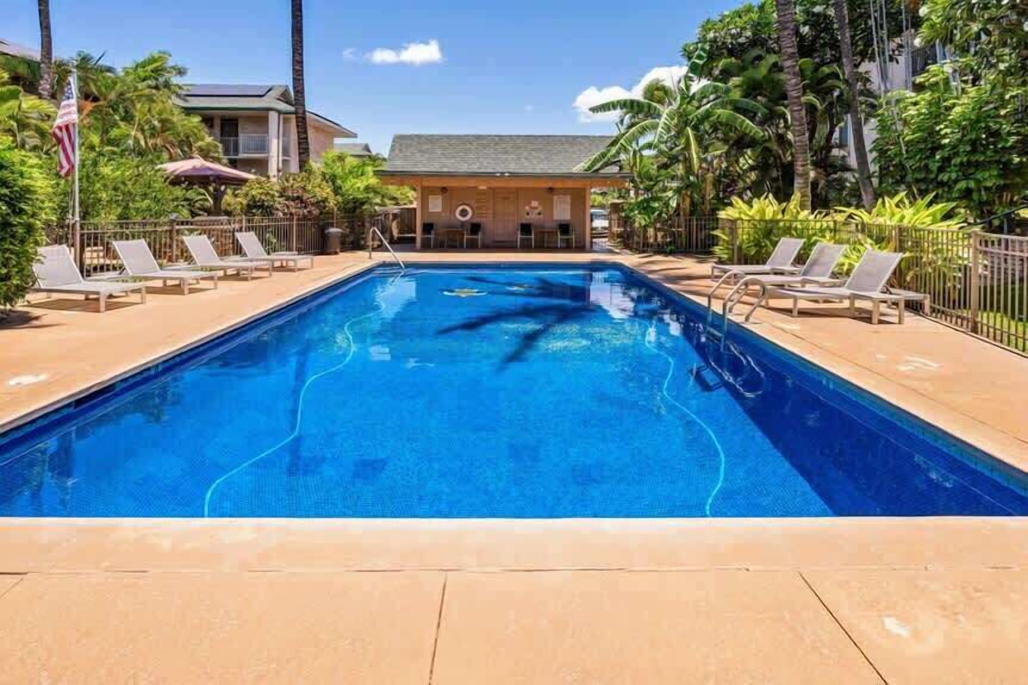 Piscina com espreguiçadeiras e posto de salva-vidas.
