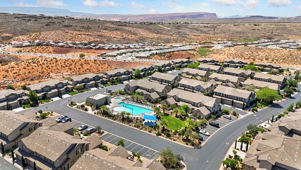 A residential area with modern houses, a central swimming pool, and a desert landscape in the background. - Casita Respite (Washington)