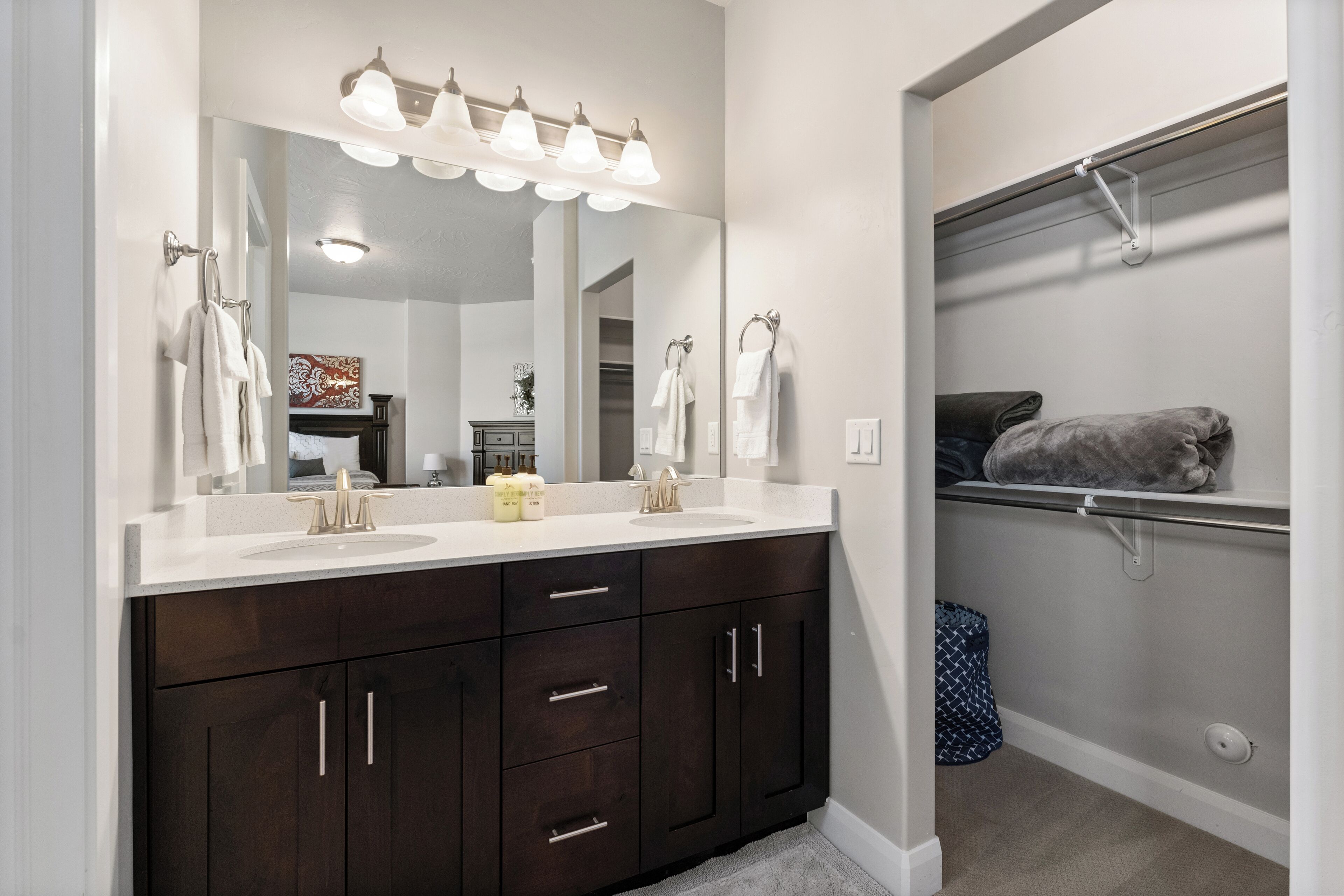 A bathroom with a double sink vanity, a large mirror, and a towel rack.