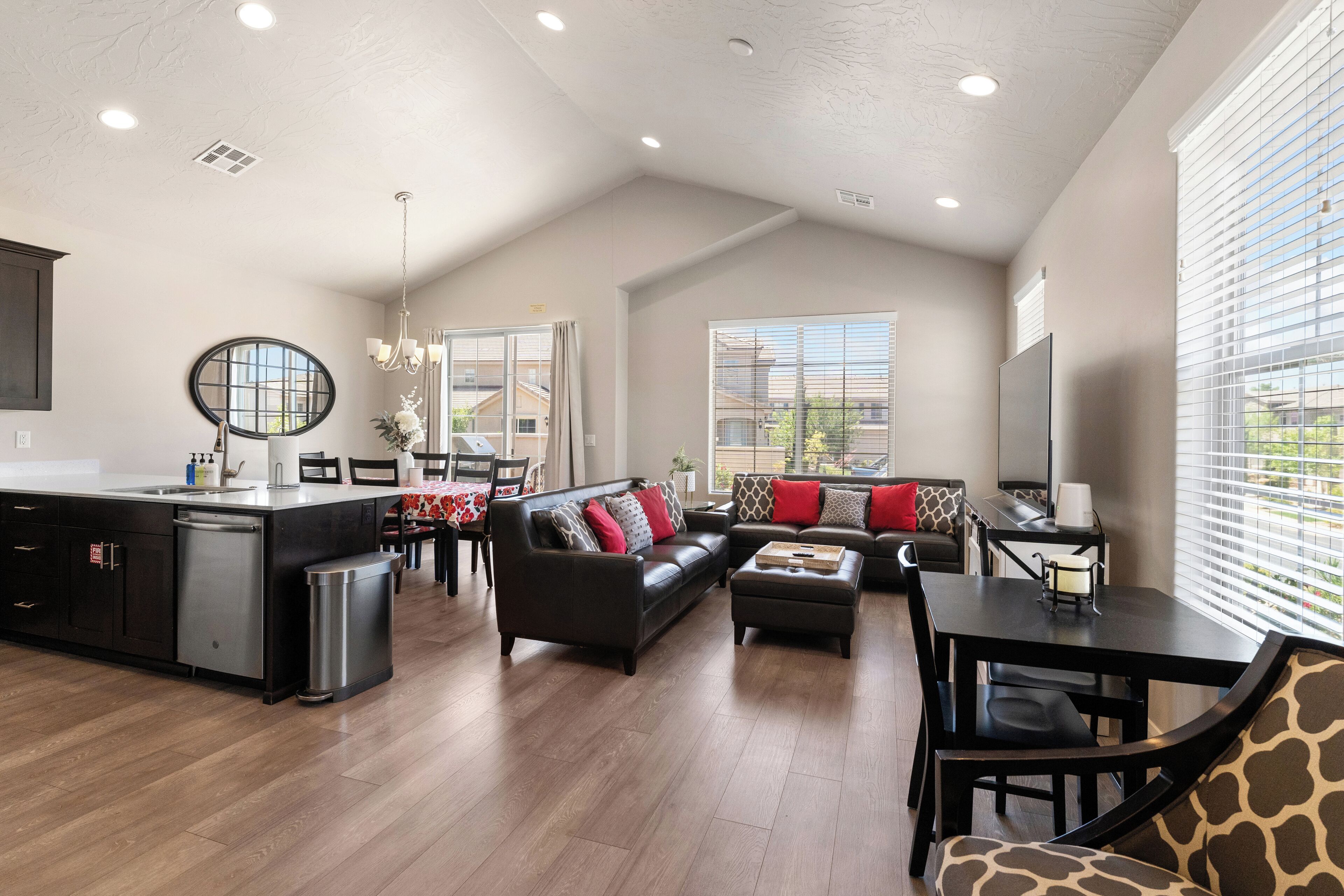 A spacious living area with a kitchen, a dining table, and a sofa set.