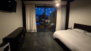 A modern hotel room with a bed, a desk, and a balcony with curtains. - Villa DPJ el Arco (Valle de Bravo)
