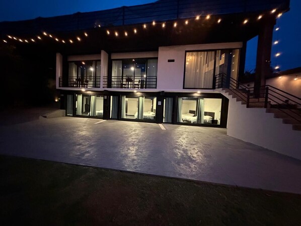 A modern hotel with a spacious outdoor area, a covered terrace, and a well-lit entrance.