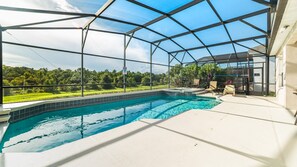 A covered outdoor swimming pool with a view of a green landscape. - Windsor Palms Resort 4 Bedroom With Game Room 0878 (Kissimmee)