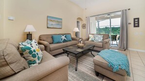Ein Wohnzimmer mit zwei Sofas, einem Couchtisch und Blick durch eine Glastür.