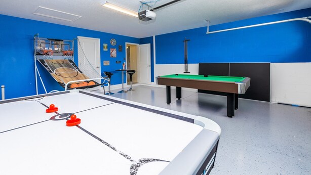 A room with a foosball table, a pool table, and a small basketball hoop. - Mvp9018sdcg (Davenport)