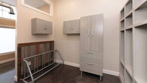 A room with a large wardrobe, a metal rack, and a mirror on the wall. - Bright Modern Loft for Adventurers (Roanoke)
