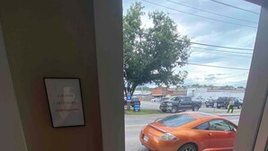 A view from inside a building looking out to a parking lot with a sign that reads "CAUTION STAY DOWN WHEN EXITING". - Bright Modern Loft for Adventurers (Roanoke)