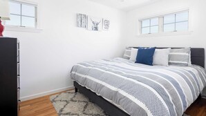 A bedroom with a bed, a dresser, and artwork on the wall. - Dunecrest by Rovetravel - Family Oceanfront With Heated Pool (Westhampton Beach)