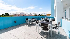 Une terrasse sur le toit, avec des sièges extérieurs et une vue sur les immeubles résidentiels.