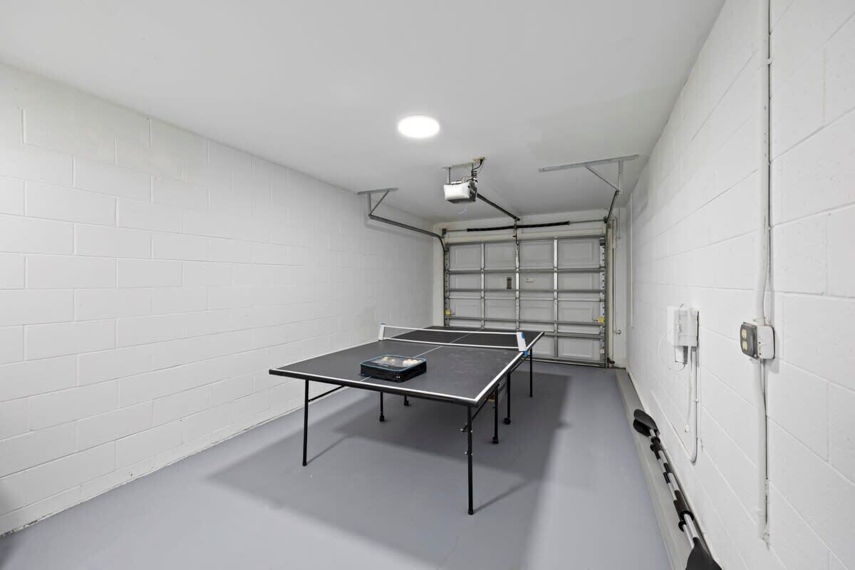 Et rum med et pingpongbord, en projektor og en garageport.