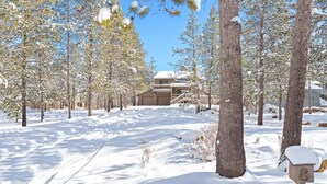 A snow-covered landscape with a building featuring a balcony and a staircase leading to the entrance. - Umpqua With Golf Views Hot Tub & Ping Pong (Bend)