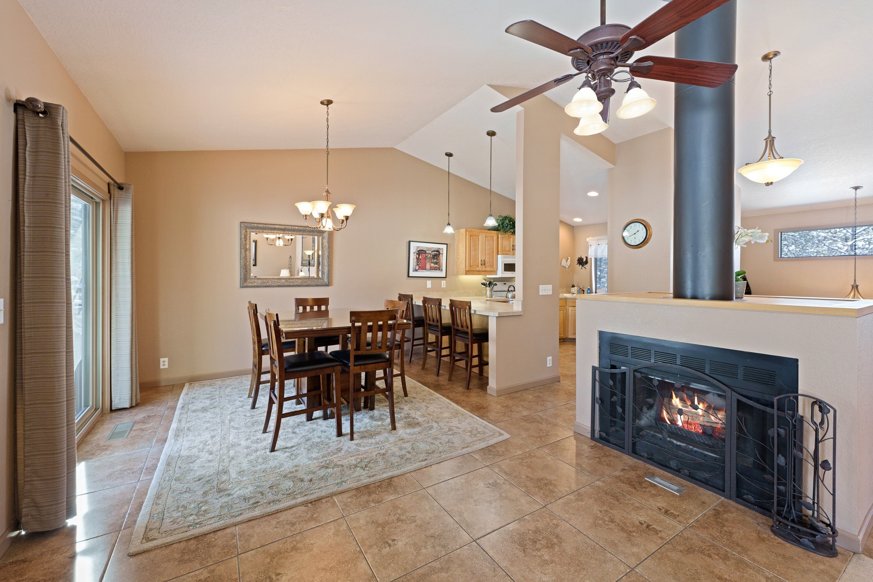 Amplia sala de estar con chimenea, comedor y cocina.