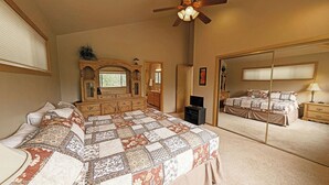 Une chambre à coucher avec un grand lit, une commode, un miroir et un dressing.