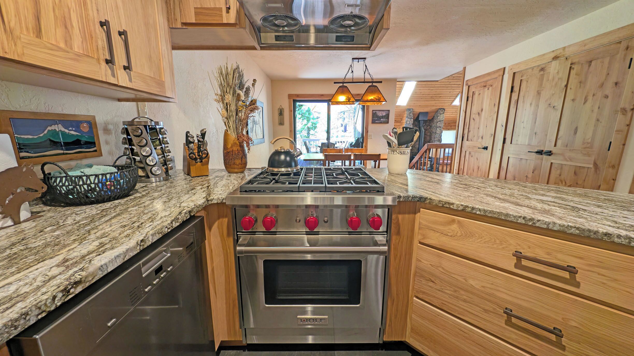 A kitchen with wooden cabinets, a stainless steel stove, and a dishwasher.