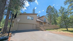 A two-story house with a covered driveway and a basketball hoop. - East Butte 14 (Bend)
