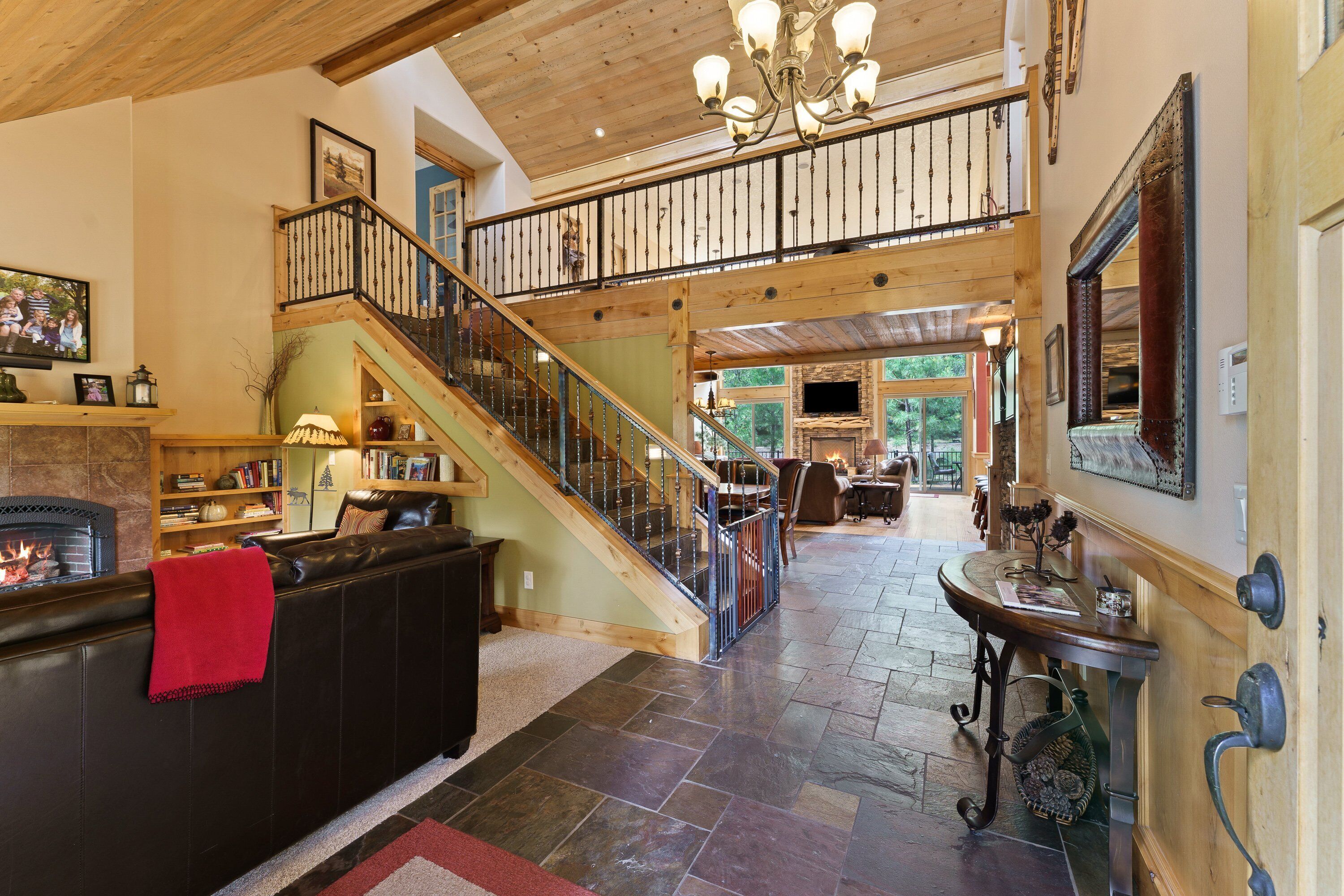 A spacious interior with a fireplace, a staircase, and a dining area.