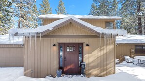 A two-story house with a snow-covered roof and icicles hanging from the eaves. - Sunriver Hot Tub Home With Sharc Passes (Bend)