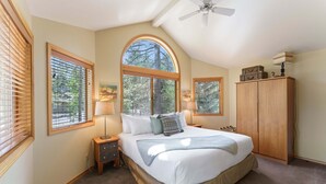 A bedroom with a large bed, two bedside tables, a wardrobe, and a ceiling fan. - Sunriver Golf Views Hot Tub Escape (Bend)