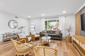 A modern living room with a sofa, two armchairs, a coffee table, and a TV. - Marbella Lane - Modern 3broasis in Siliconvalley (San Jose)