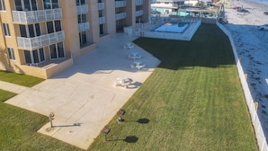 A multi-story hotel with balconies, a pool area, and a beach view. - Oceania Beach Club 203 (New Smyrna Beach)
