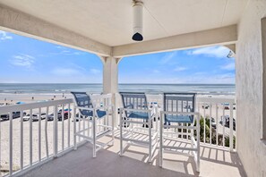 A balcony with white chairs and a view of the beach. - Win-san C315 (New Smyrna Beach)