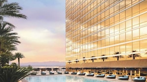 A modern hotel with a large pool, palm trees, and a view of the ocean. - Stylish Renovated Studio at Trump Tower 2804 (Las Vegas)