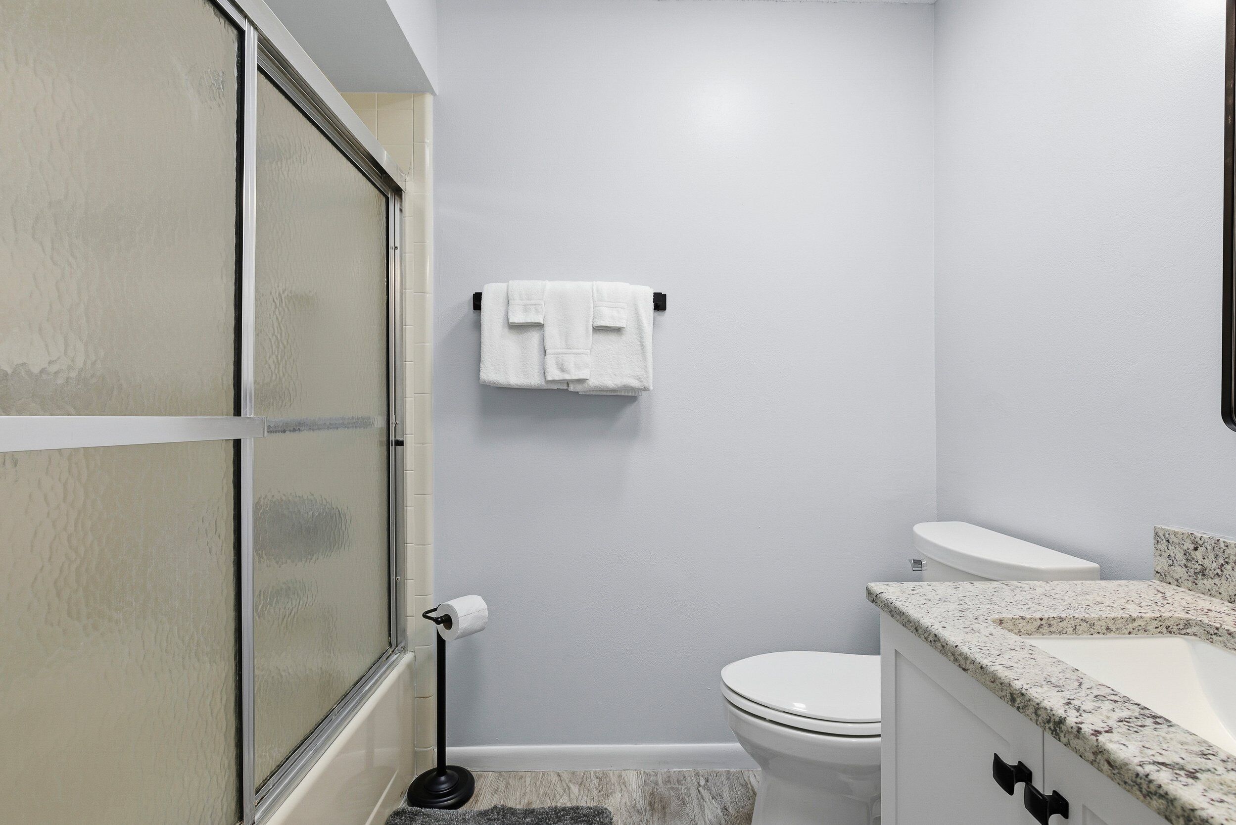 A bathroom with a toilet, sink, and towel rack.