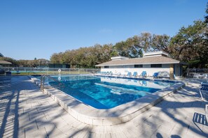 A swimming pool with a tiled deck, lounge chairs, and a fenced area. - Sea Woods Villa 4350 (New Smyrna Beach)