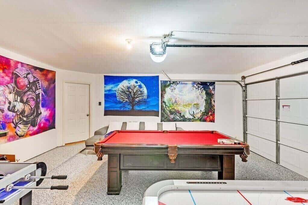 Une pièce équipée d’une table de billard, d’une table de snooker et ornée de trois tableaux.