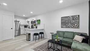 A modern kitchen with white cabinets, stainless steel appliances, and a central island. - Modern 4BR 2BA Home With Hot Tub-grill & Huge Yard (Haltom City)
