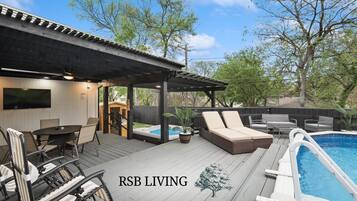 A deck with outdoor furniture, a hot tub, and a pool.