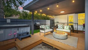 An outdoor patio with a grill, seating area, and string lights. - Spacious 5BR 3BA Retreat With Pool & Hot Tub (Duncanville)