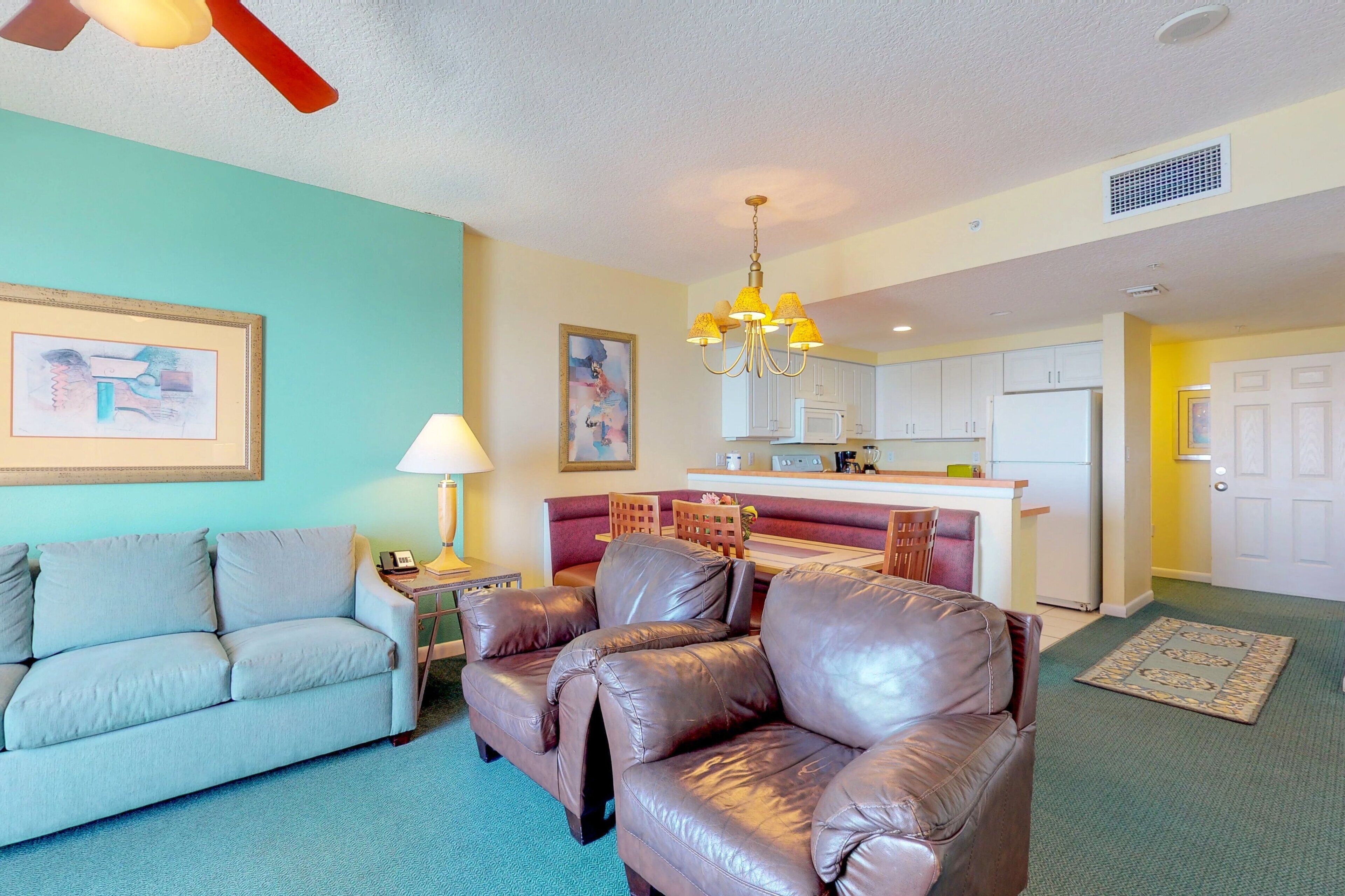 A living room with a sofa, a loveseat, a lamp, and a painting on the wall.