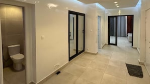 A modern hallway with recessed ceiling lights, a visible toilet, and a door leading to another room. - DAKAR VDN: Furnished apartment for rent- 2 bedrooms- Living room - 3 bathrooms (Dakar)