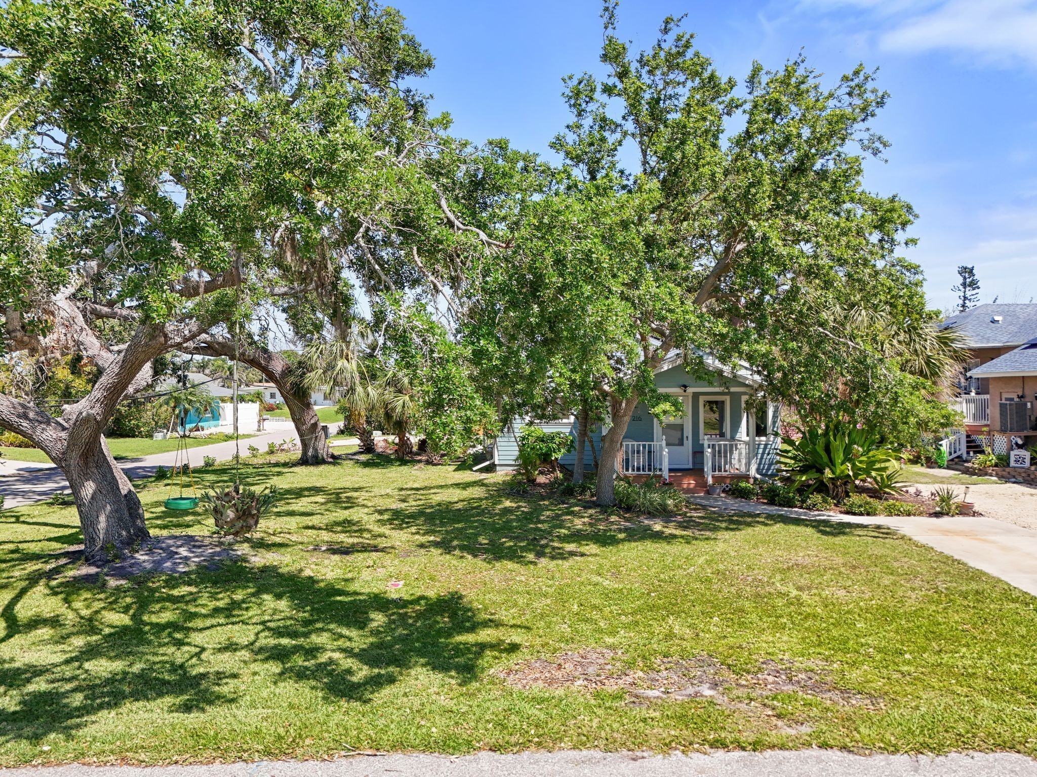 A residential area with a house featuring a porch and a swing.