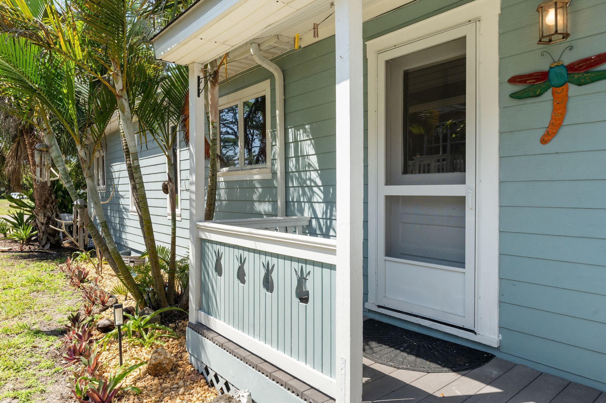 A house with a porch, a window, and a decorative dragonfly.