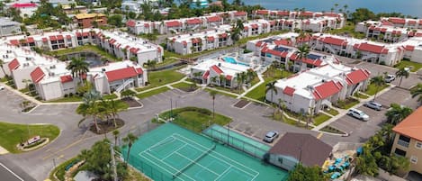 A residential area with multiple two-story buildings, a tennis court, and a parking lot.