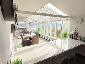 A modern kitchen with a large island, a dining area with a view, and a skylight. - 3 Bedroom with Fantastic Lake Union and Seattle Skyline view. 10 min to downtown (Seattle)