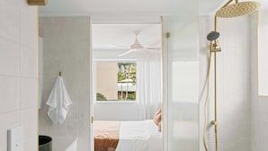 Un bagno moderno con doccia, ventilatore a soffitto e vista esterna.