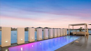 A swimming pool with a view of the sea and mountains in the background. - Elegant Waterfront Escape – Point Cook

Relax with the whole family. (Point Cook)