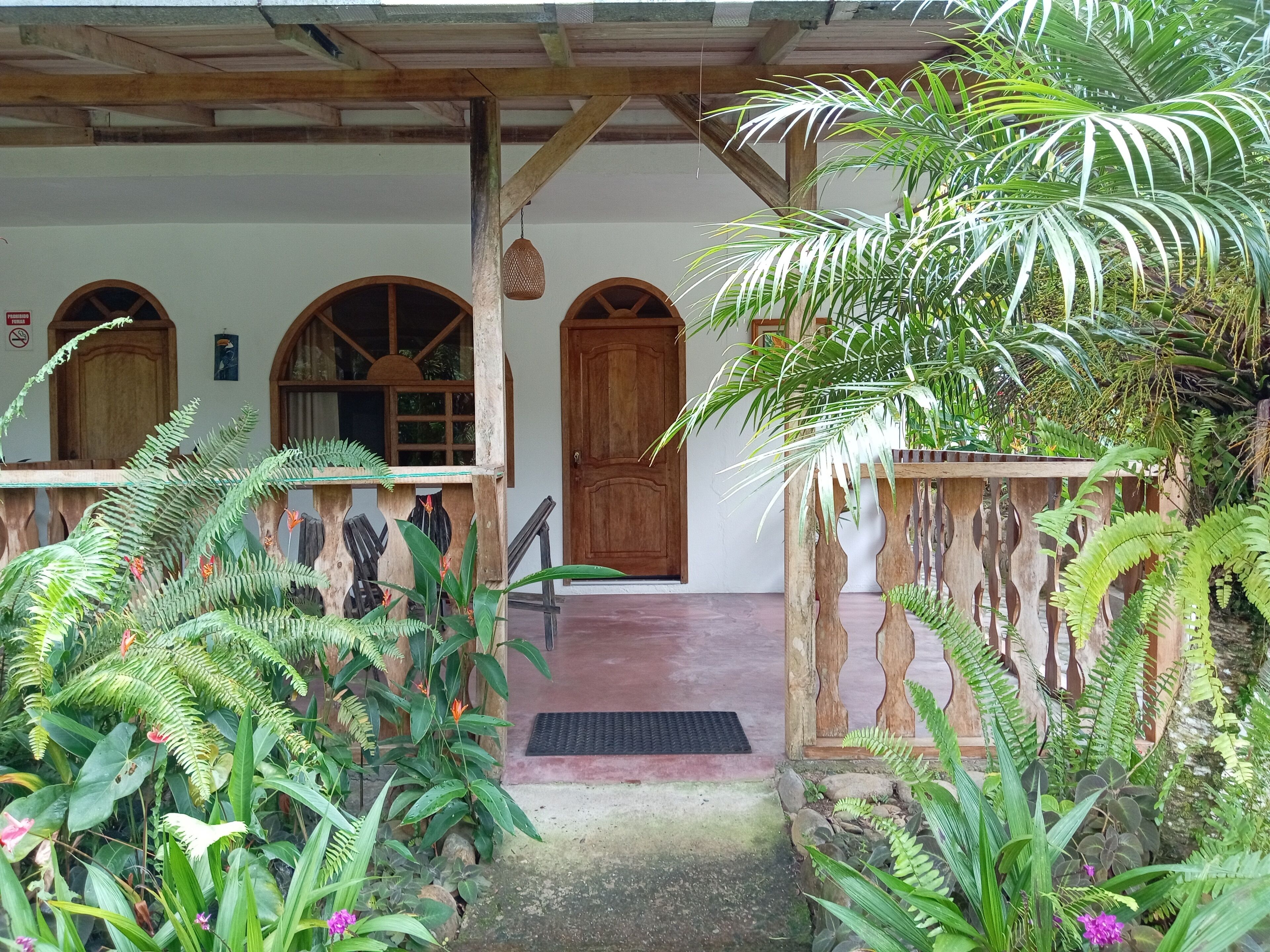 A covered porch with wooden beams and a wooden door.