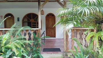 A covered porch with wooden beams and a wooden door.